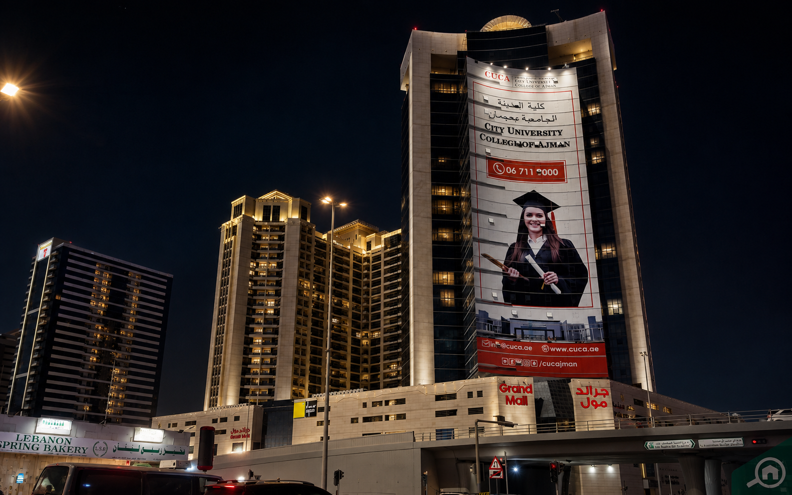 Grand Mall and Ajman city towers illuminated at night